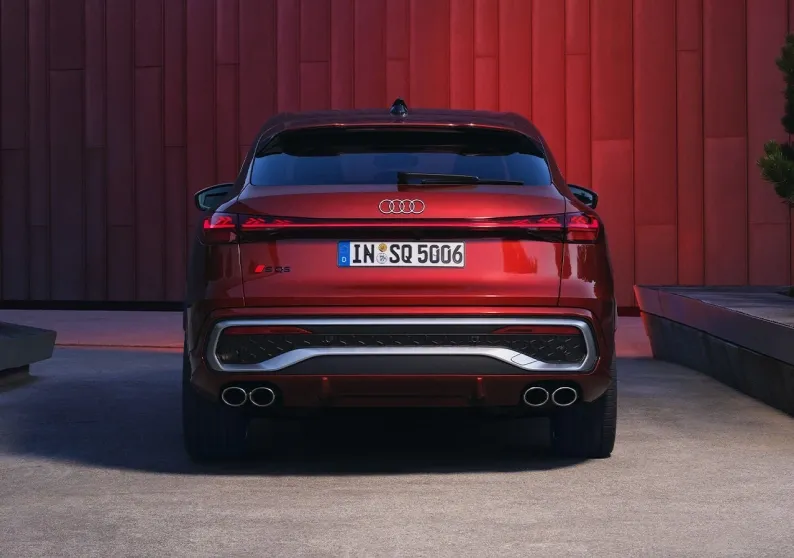 Audi SQ6 e-tron Sportback vermelho visto de trás, estacionado diante de uma parede vermelha