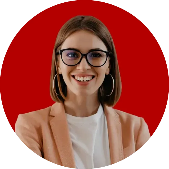 Mulher branca e loira sorrindo usando óculos e vestindo um blazer com camiseta branca