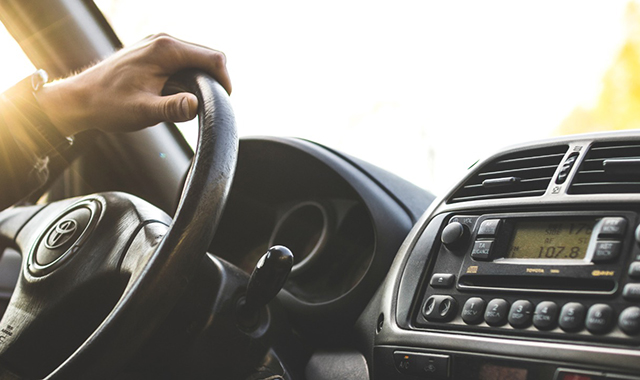 Motorista atento no volante de um carro em via urbana