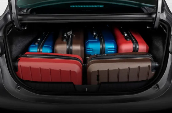 Família carregando malas em carro com porta-malas grande