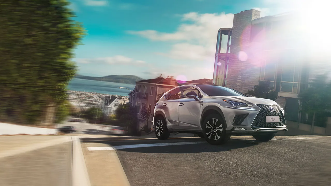 Lexus NX híbrido branco em movimento numa avenida à beira-mar