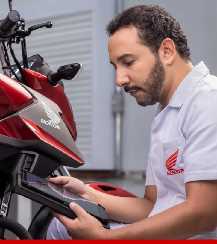 Mecânico Honda fazendo a manutenção de uma moto na oficina