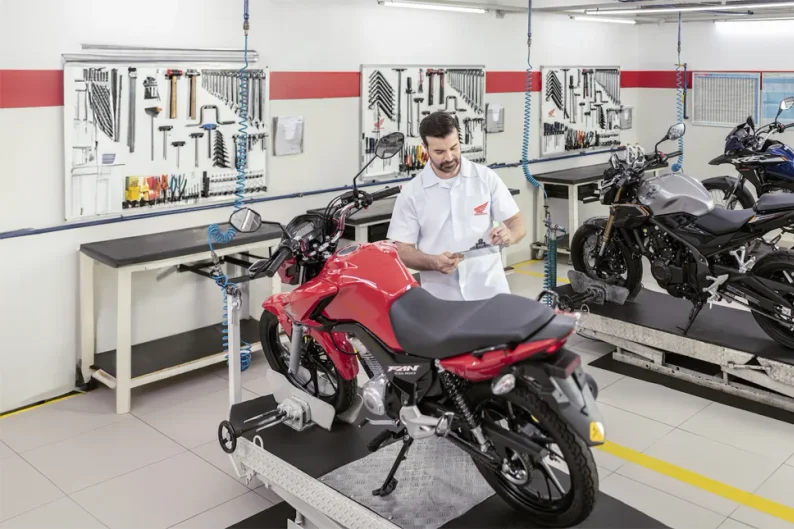 Mecânico Honda fazendo o checklist de uma moto na oficina da concessionária