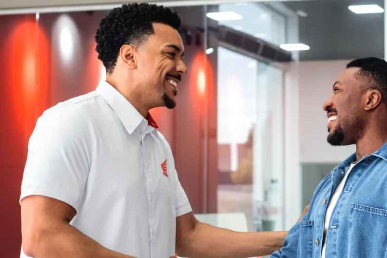 Consultor Honda cumprimentando um cliente no salão da concessionária