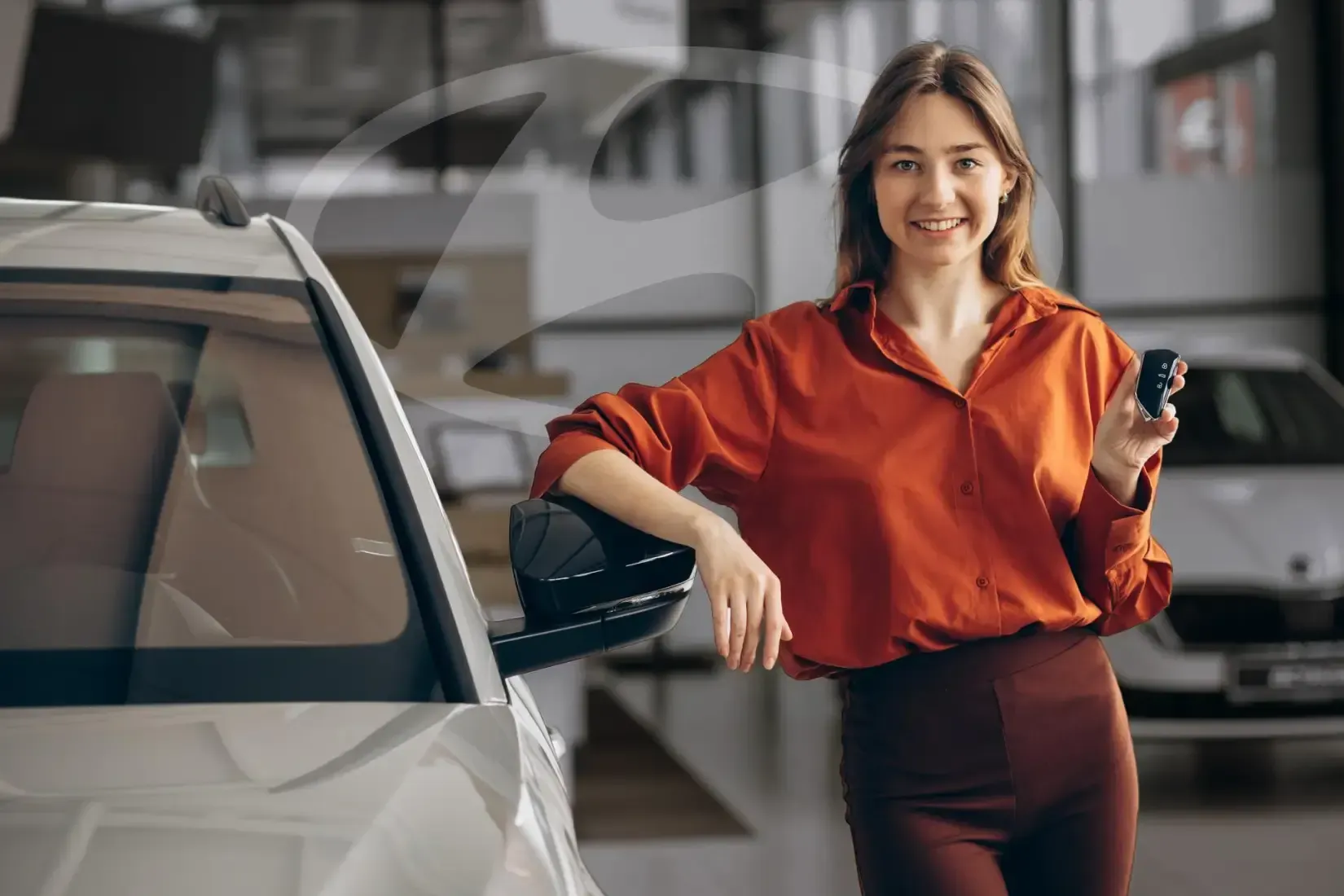 Mulher segurando uma chave de carro apoiada no retrovisor de um carro.