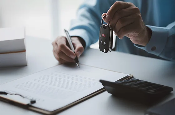 Homem e mulher sorrindo, analisando documentos de financiamento de carro em uma concessionária