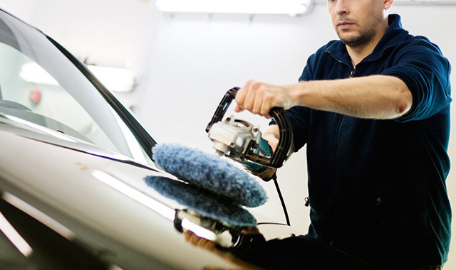 Homem verificando o motor de um carro com ferramentas