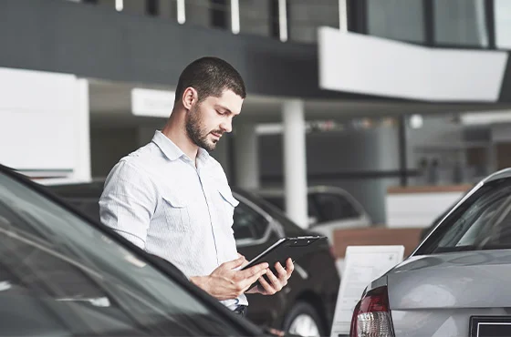 Pessoas analisando opções de mobilidade com carro e celular.