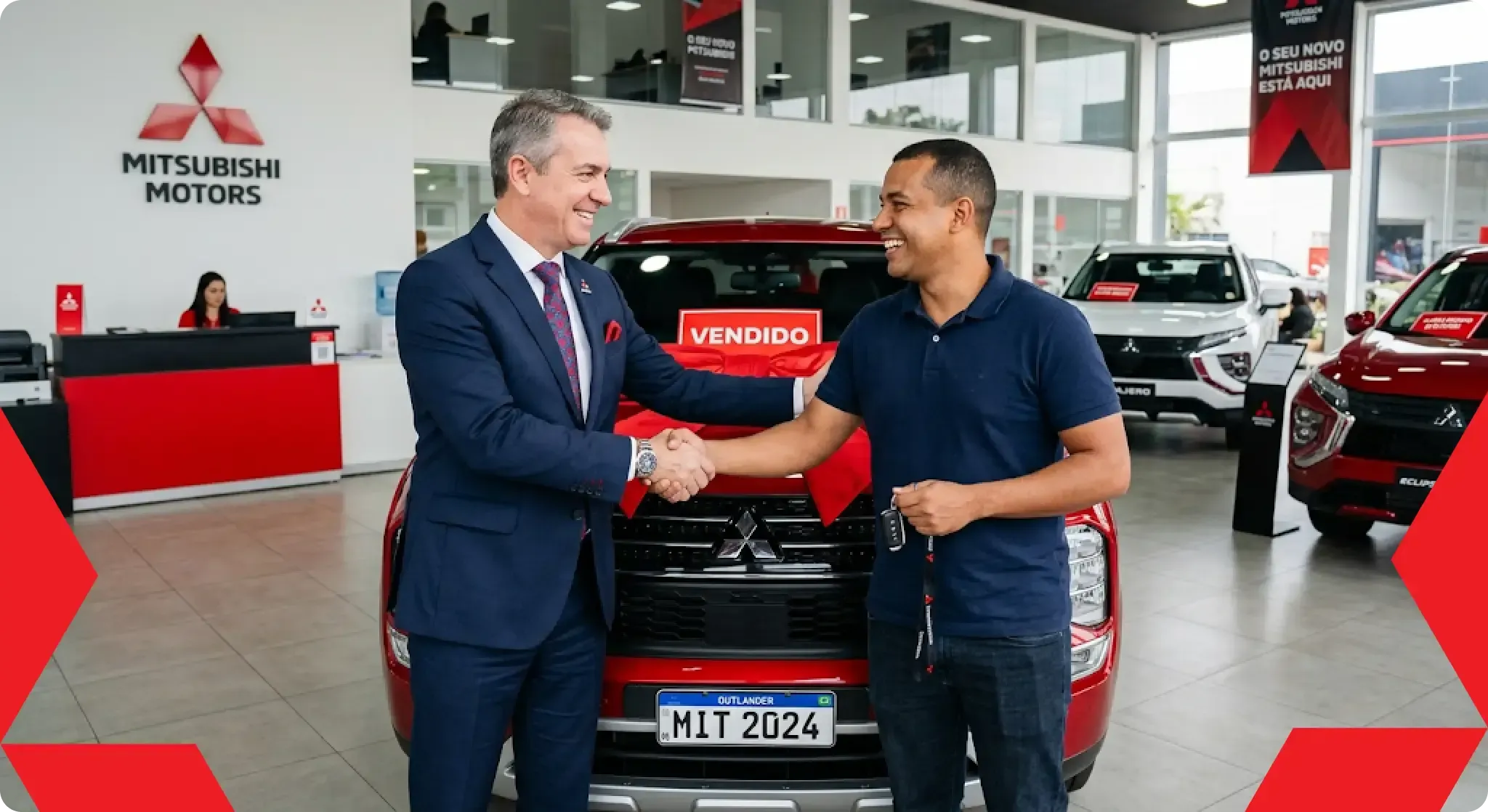 Duas pessoas sorrindo e apertando as mãos em uma concessionária, com um carro da Mitsubishi atrás delas.