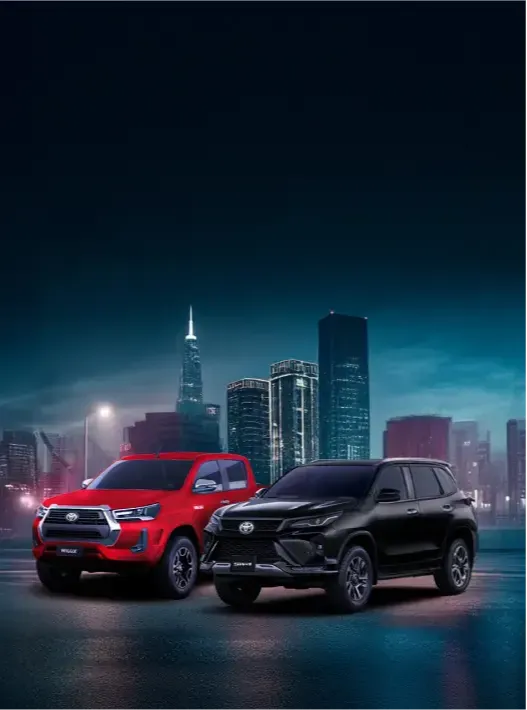Dois carros Toyota em uma cidade a noite