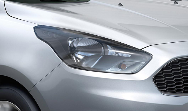Pessoa preenchendo formulário de imposto de renda com carro no fundo.