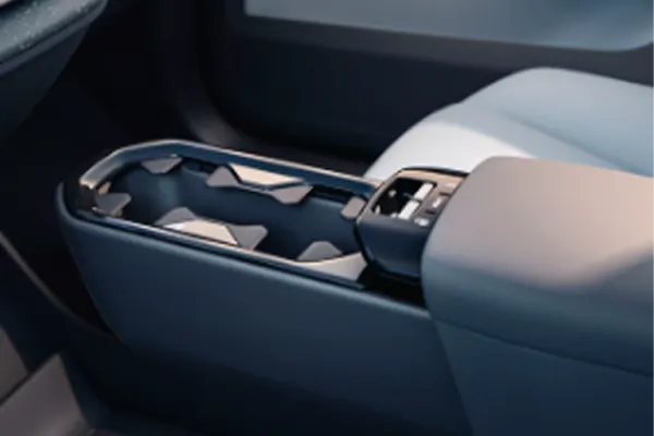 Console central com porta-copos e apoio de braço em tons de azul no interior de um Volvo