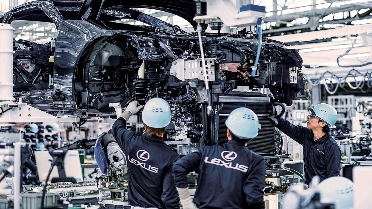 Técnicos Lexus uniformizados trabalhando na linha de montagem