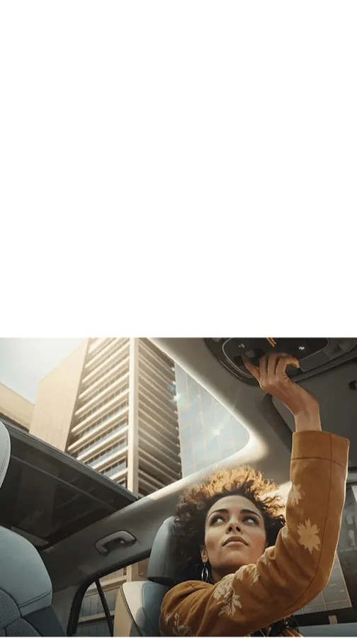 Mulher dentro de um veículo Hyundai mexendo no painel do teto.