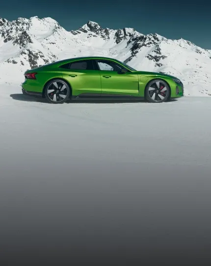 Audi RS e-tron GT verde parado na neve, com montanhas nevadas ao fundo