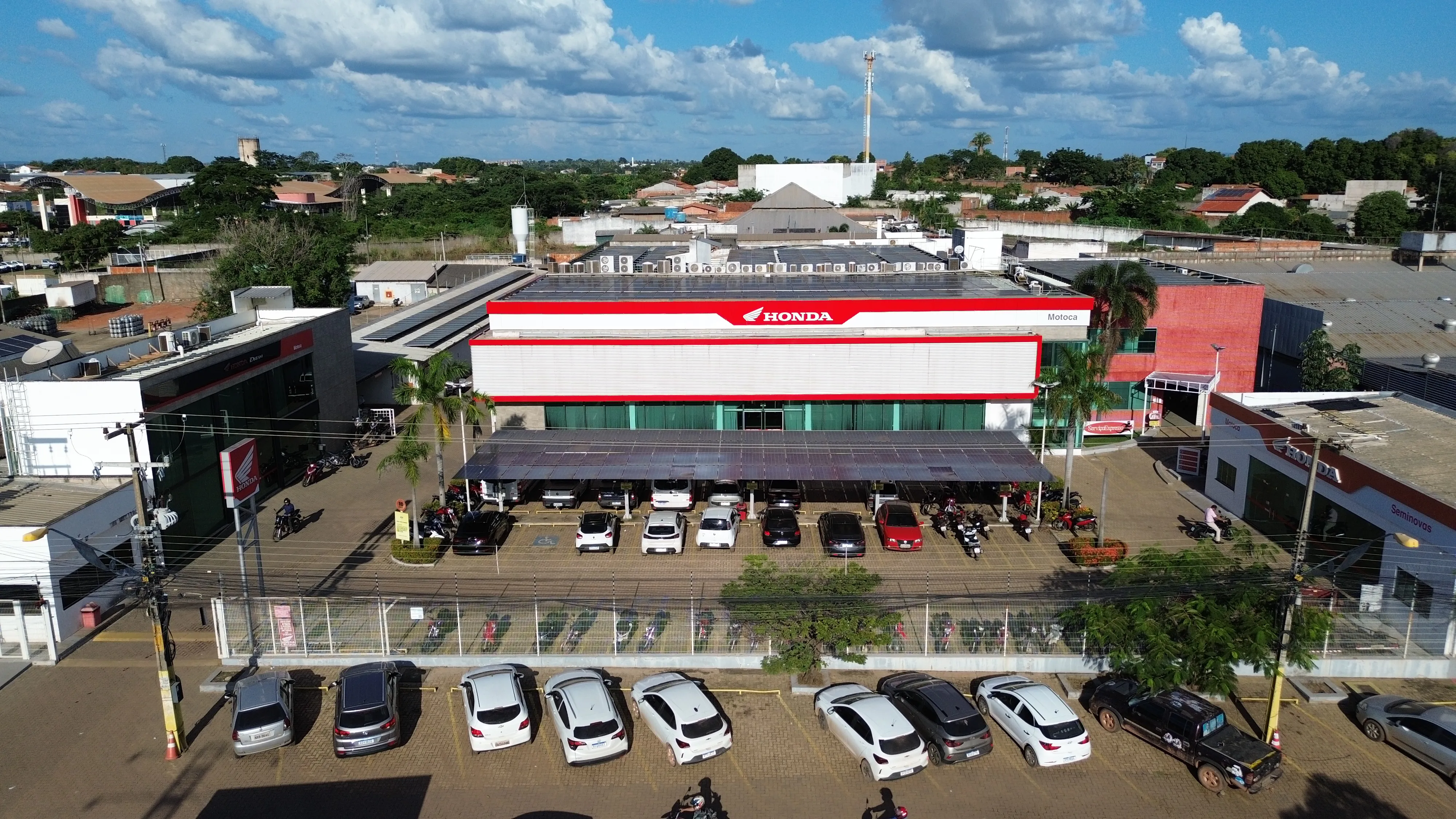 Imagem de uma mulher em cima de uma moto Honda em frente a uma concessionária