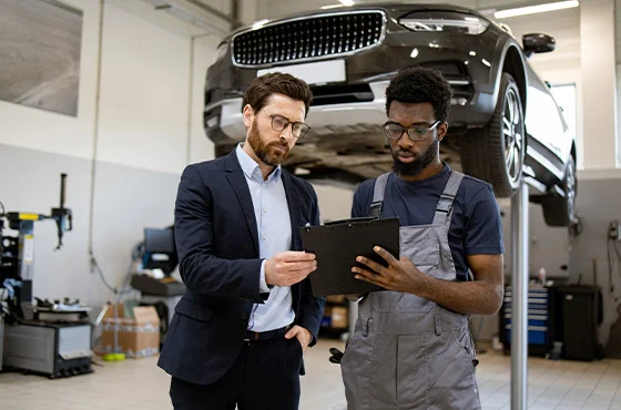 Mecânico em concessionária inspecionando motor de carro novo