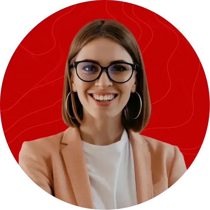 Mulher branca e loira sorrindo usando óculos e vestindo um blazer com camiseta branca