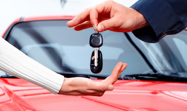 Pessoa pensativa olhando para dois carros, um antigo e um novo
