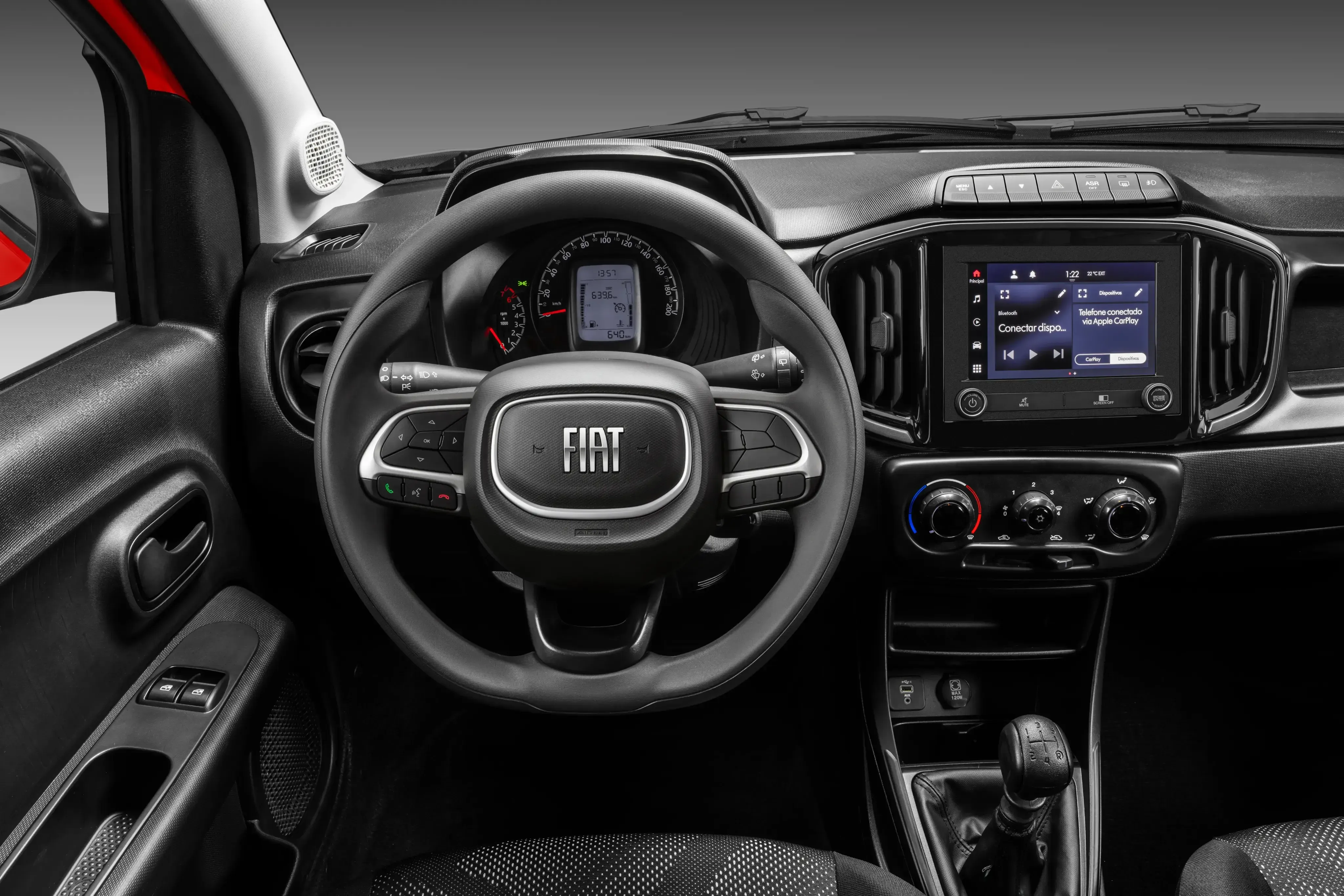 Interior de veículo Fiat, com painel moderno, volante multifuncional e acabamento em tons escuros.
