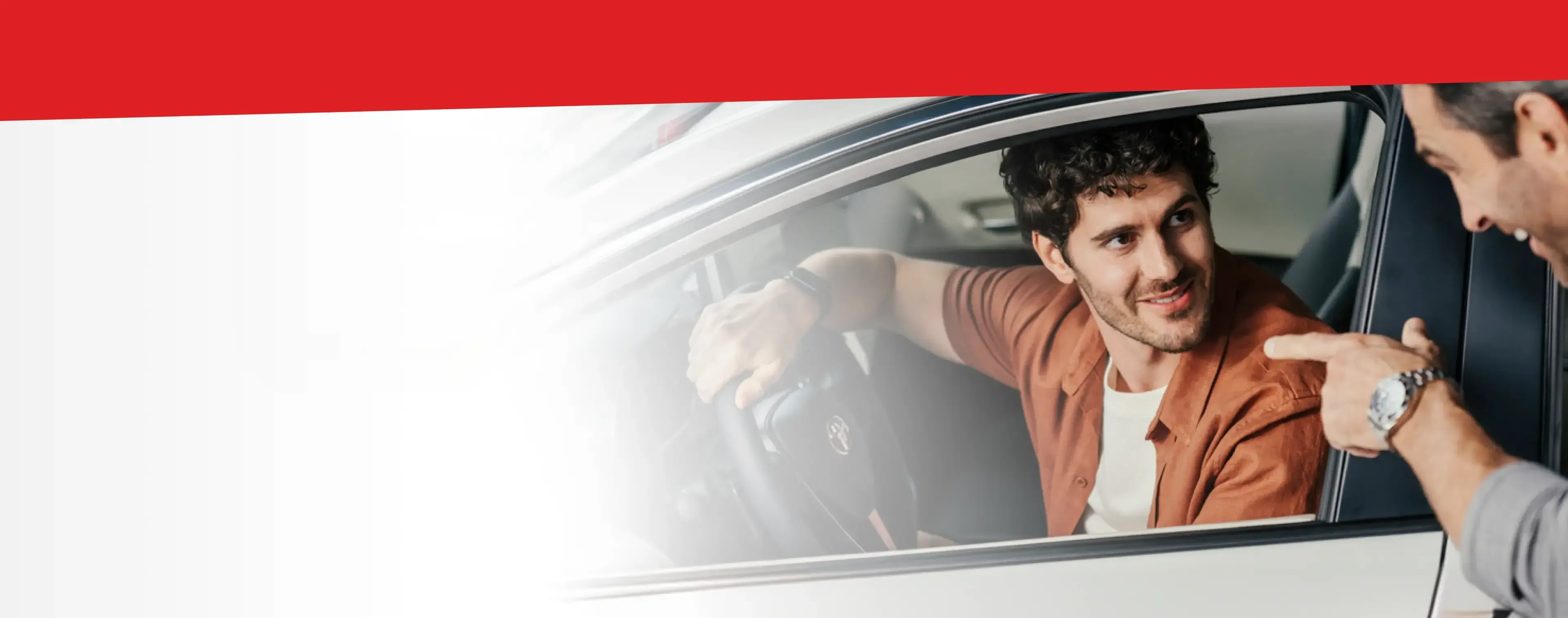 Dois homens conversando, um dentro de um carro.