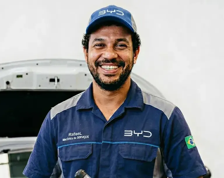 Imagem de um mecânico realizando um serviço na parte inferior de um carro.